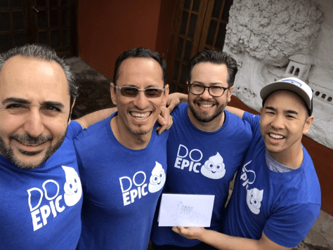 Peru-execs CEO Ali Manouchehri huddled with other MetroStar employees wearing company spirit shirts emphasizing our government IT services