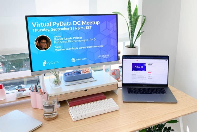 A picture of a desk with a monitor and a laptop open with screens showing pydata dc meetup